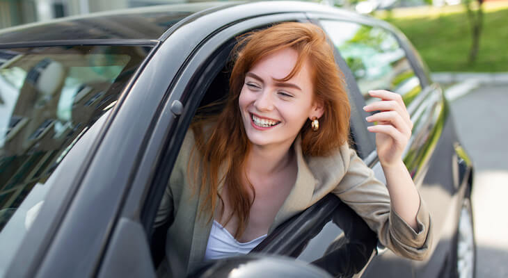 Woman happily riding in a car with the best car insurance with bad credit