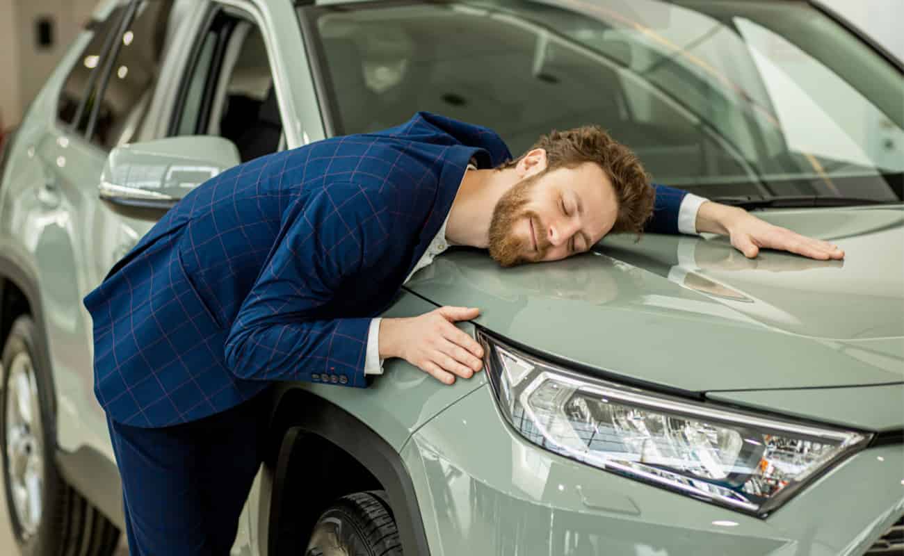  man smiling with car after getting car insurance
