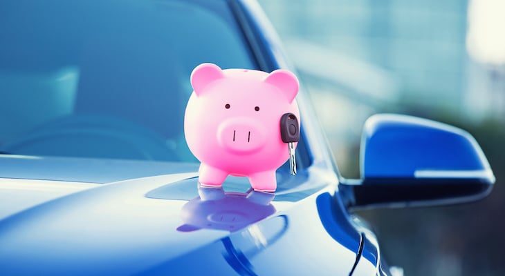 Can you negotiate car insurance: piggy bank on the hood of a car