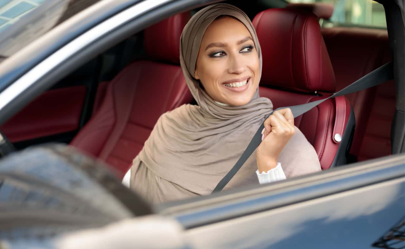 woman smiling while sitting in her car