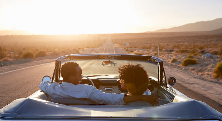 Couple happily driving away in their convertible