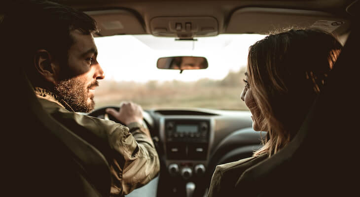 Car insurance married vs single: couple looking at each other while in their car