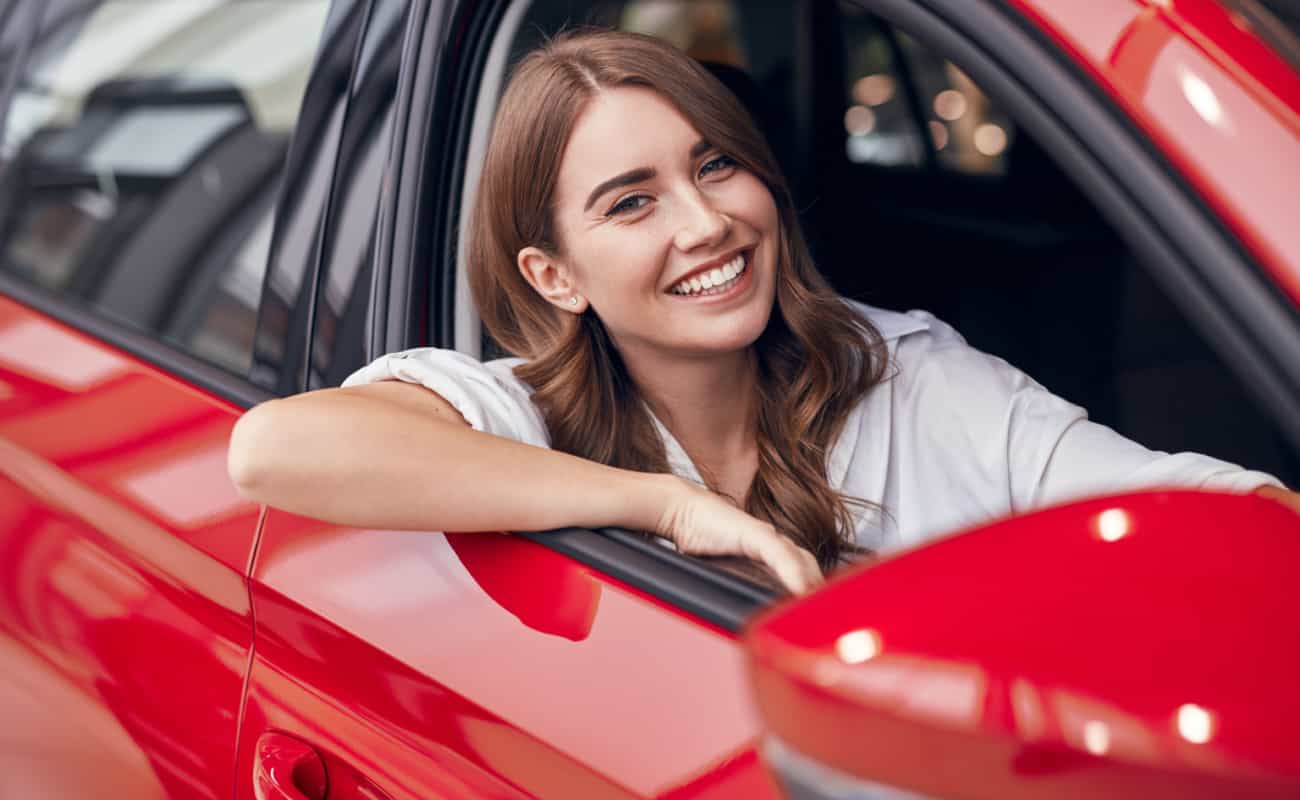 woman smiling while sitting in her car