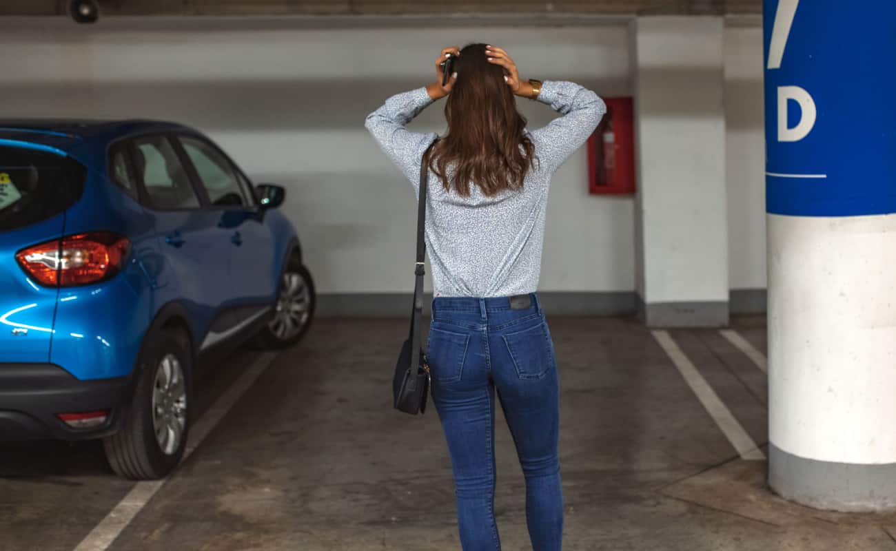 woman standing in parking garage because her car was stolen