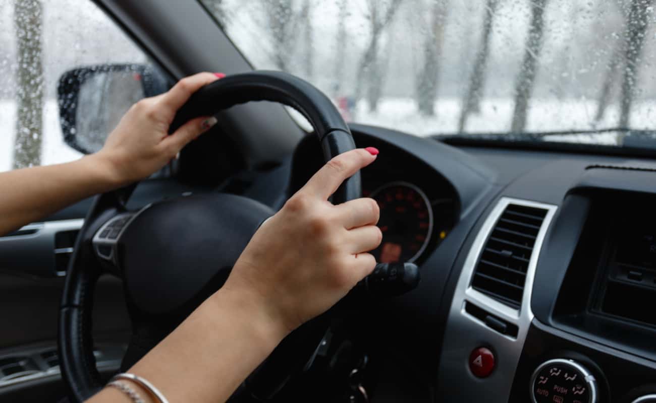  young female driver with hands on steering wheel