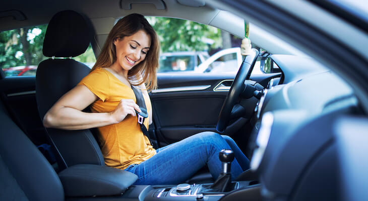 Usage based insurance: woman putting on her seat belt