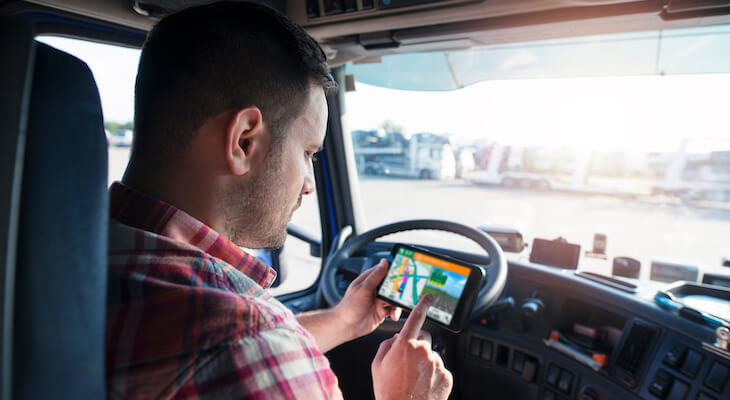 Truck driver looking at a GPS mobile app