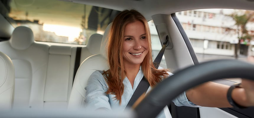 White woman with red hair and blue shirt driving