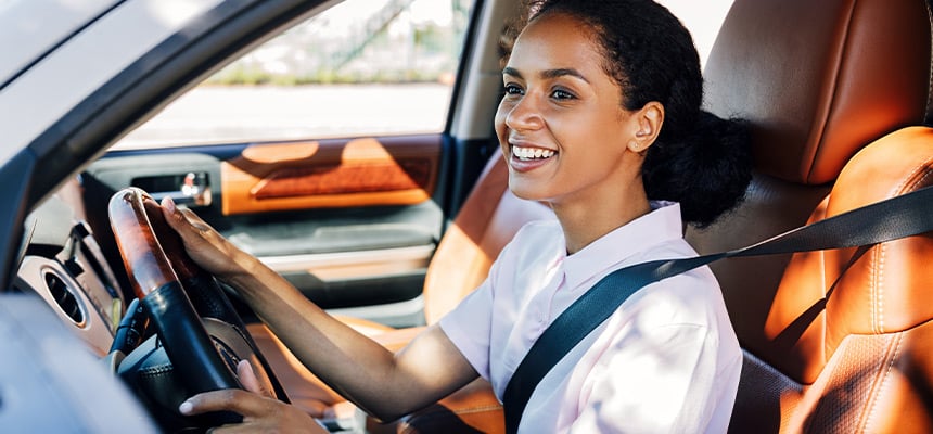 black woman in white shirt driving 