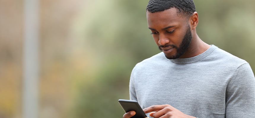 Man using his phone to research how to save on auto insurance
