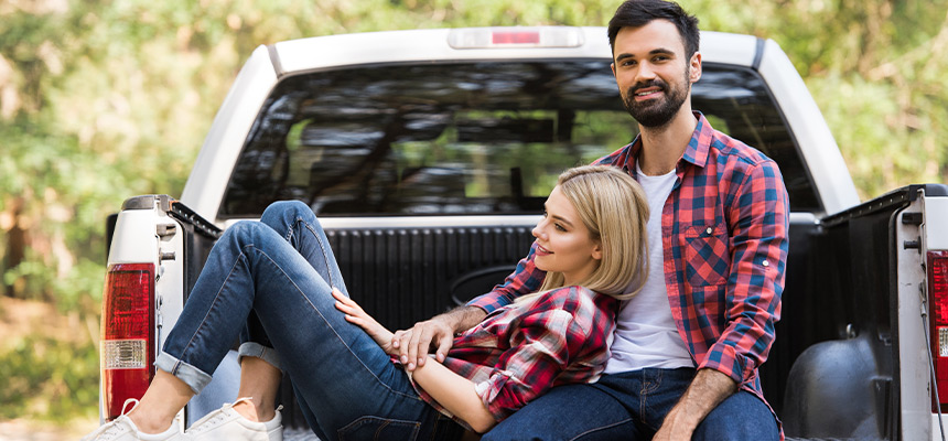 Couple relaxing in the bed of a pickup truck