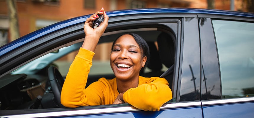 black woman in yellow shirt smiling hold car keys