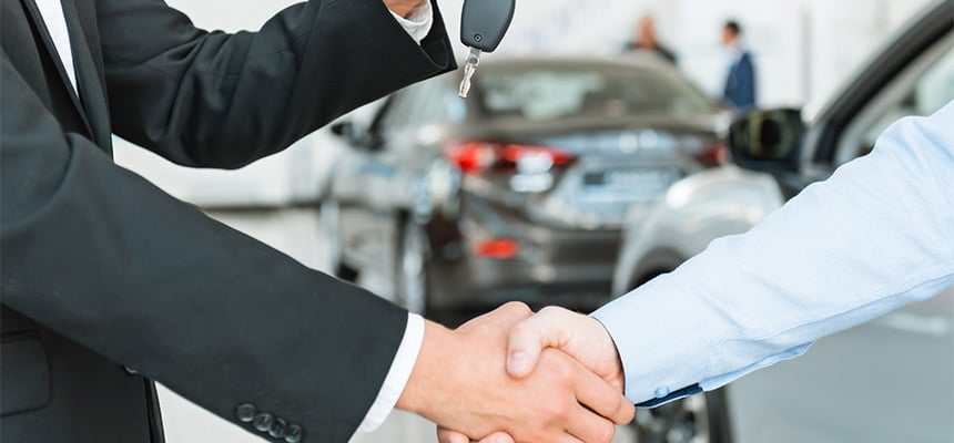 men shaking hands while being handed car keys