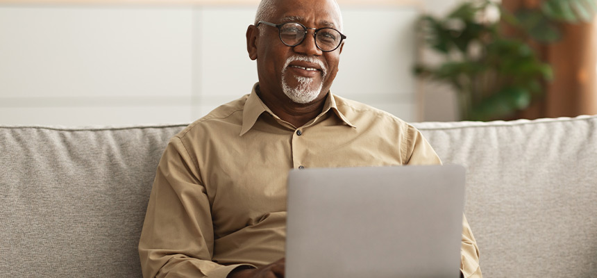 older man looking for car insurance on laptop