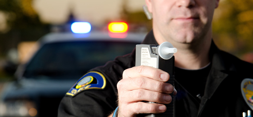 police officer holding breathalizer test