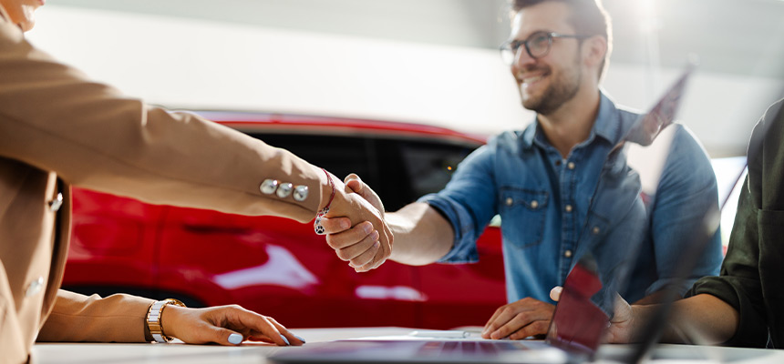 Closeup of a handshake on a car dealership