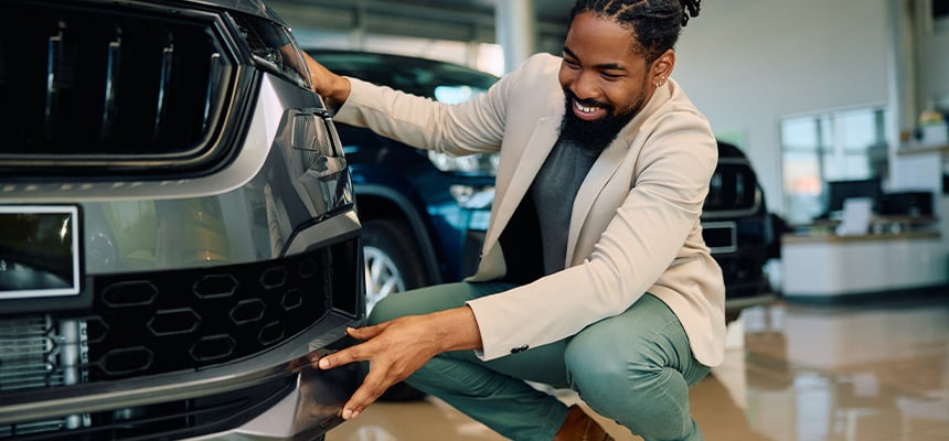 Smiling man inspecting new car