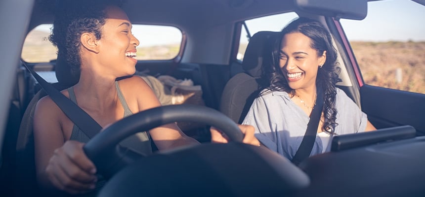 Young couple smiling as they drive car